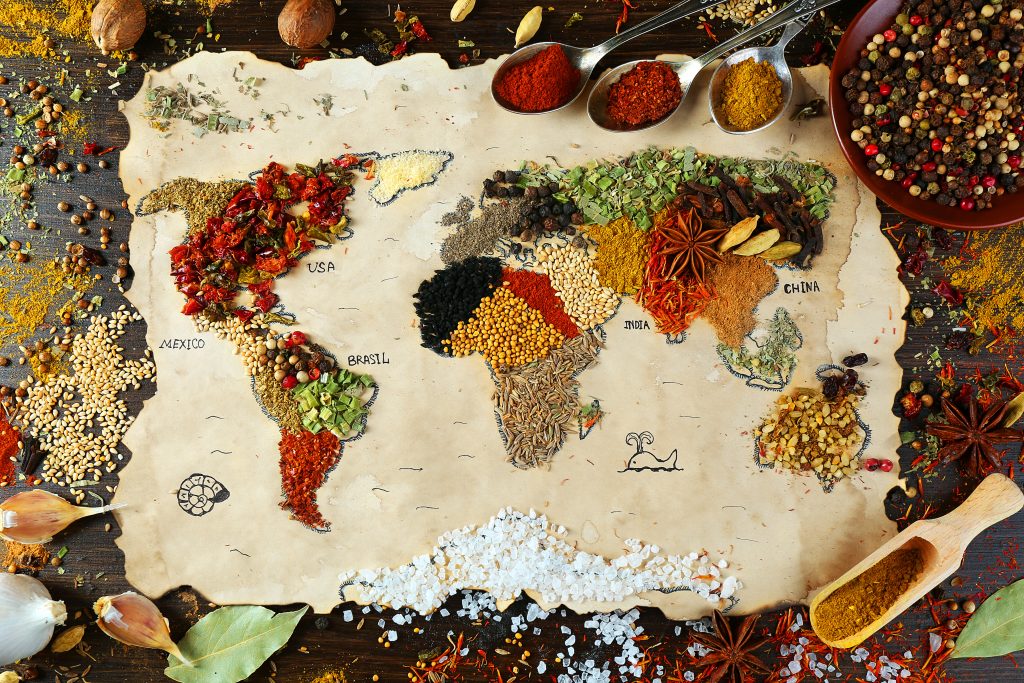 Map of world made from different kinds of spices on wooden background