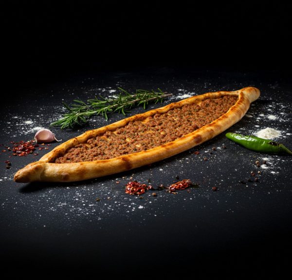 Meat pie with flour scattered around it and a dark background
